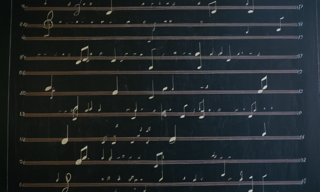 Una fusión de código de programación funcional y notas musicales en una pizarra.